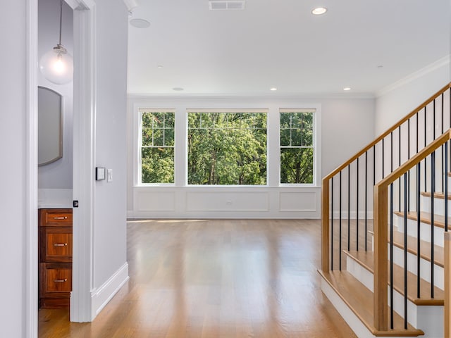 interior space featuring light wood-type flooring and crown molding