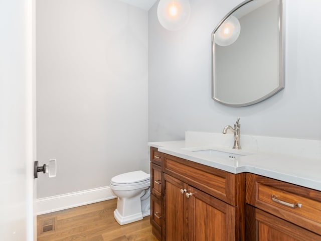 bathroom featuring hardwood / wood-style flooring, vanity, and toilet