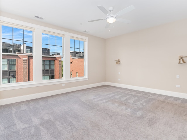 spare room with ceiling fan and carpet