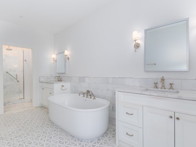 bathroom with tile patterned floors, tile walls, vanity, and independent shower and bath