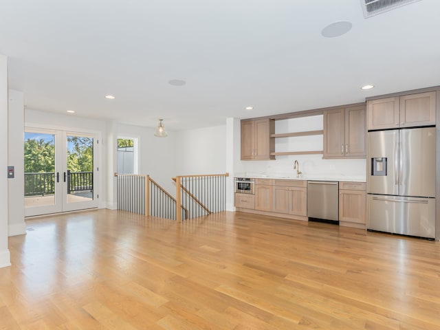 kitchen featuring sink, stainless steel appliances, light hardwood / wood-style floors, and light brown cabinets