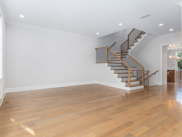 interior space featuring sink, a notable chandelier, crown molding, and light hardwood / wood-style floors