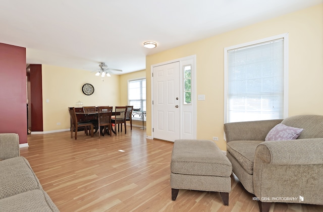 living room with light hardwood / wood-style flooring and ceiling fan