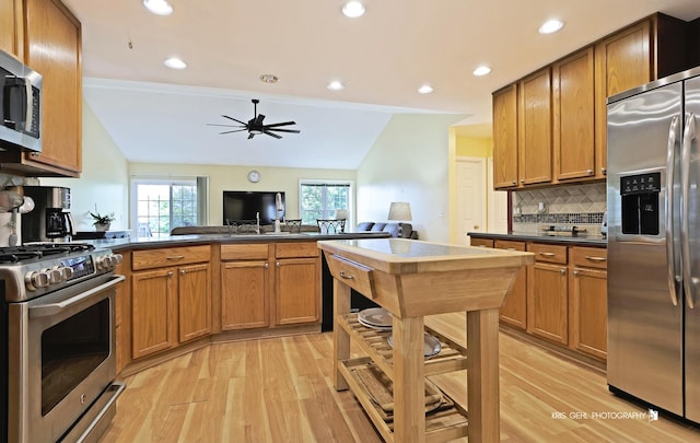 1214 Jerome Ct E, Antioch, IL 60002 - kitchen featuring appliances with stainless steel finishes, light wood-style flooring, vaulted ceiling, dark countertops, and backsplash