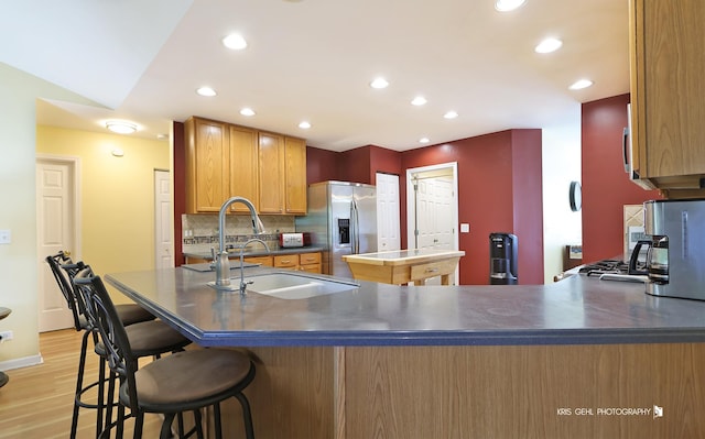 1214 Jerome Ct E, Antioch, IL 60002 - kitchen with stainless steel fridge, a sink, a kitchen island, light wood-style floors, and tasteful backsplash