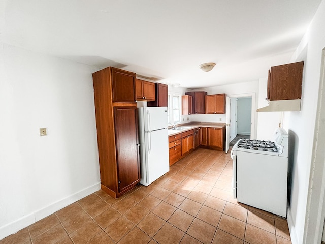 kitchen featuring white appliances, sink, and light tile patterned floors