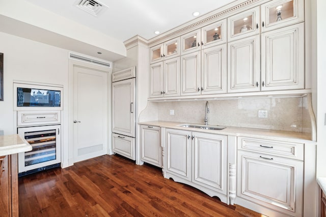 kitchen with dark hardwood / wood-style flooring, wine cooler, sink, and tasteful backsplash