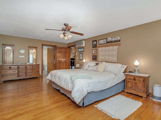 bedroom featuring ceiling fan, a wall unit AC, and light hardwood / wood-style flooring