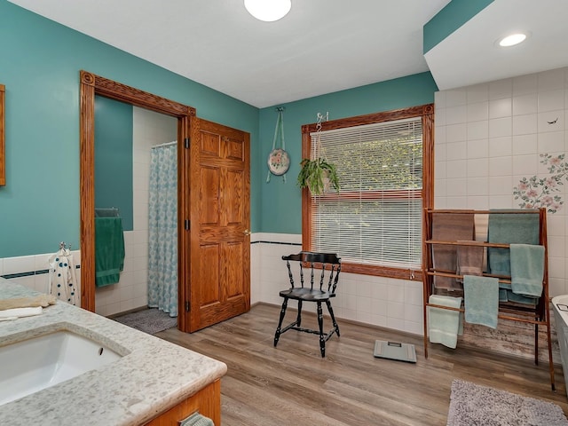 bathroom with hardwood / wood-style floors, tile walls, and vanity