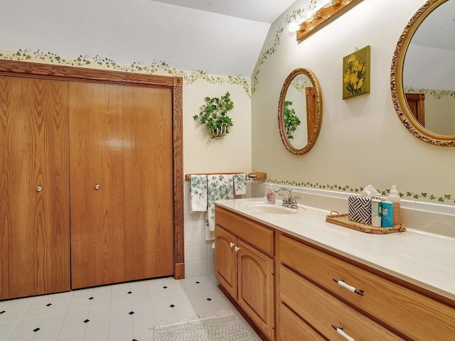 bathroom featuring vanity, vaulted ceiling, and tile patterned flooring