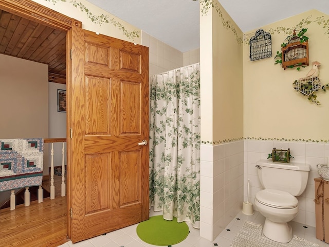 bathroom featuring wood-type flooring, tile walls, and toilet