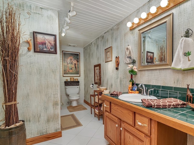 bathroom featuring track lighting, vanity, toilet, and tile patterned flooring