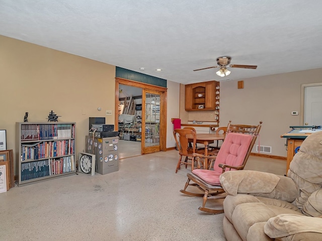 living room with a textured ceiling and ceiling fan