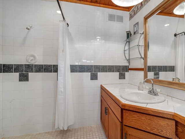 bathroom featuring tile patterned floors, tile walls, and vanity