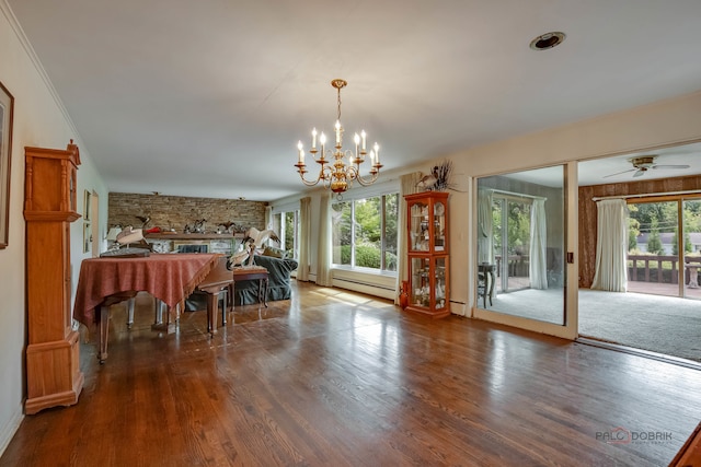 dining space with ceiling fan with notable chandelier, a baseboard radiator, and hardwood / wood-style floors