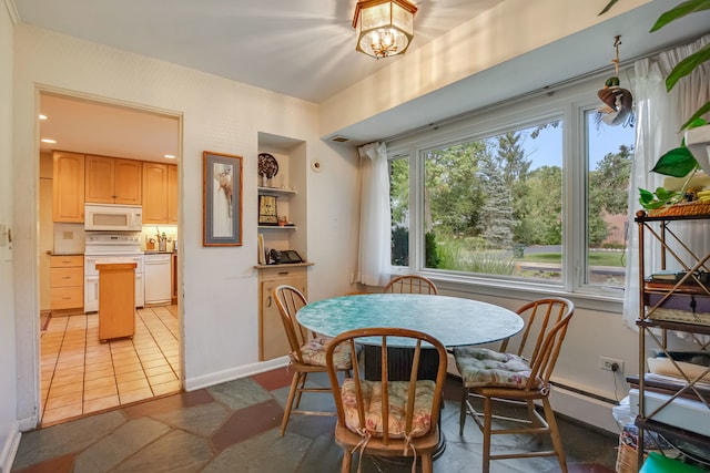 tiled dining area featuring baseboard heating and a chandelier