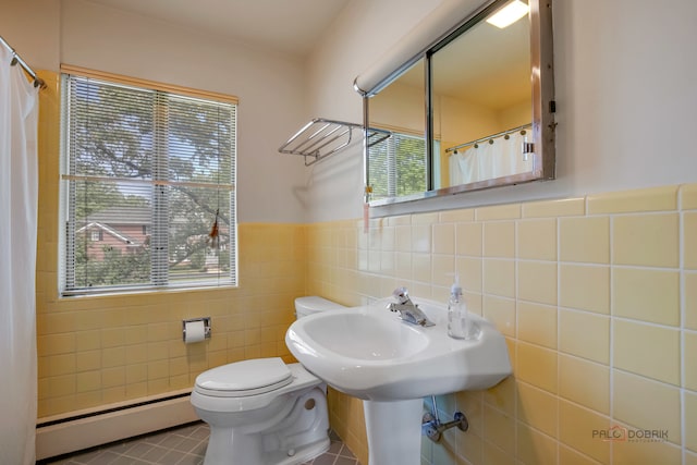 bathroom with a baseboard heating unit, tile patterned flooring, and tile walls