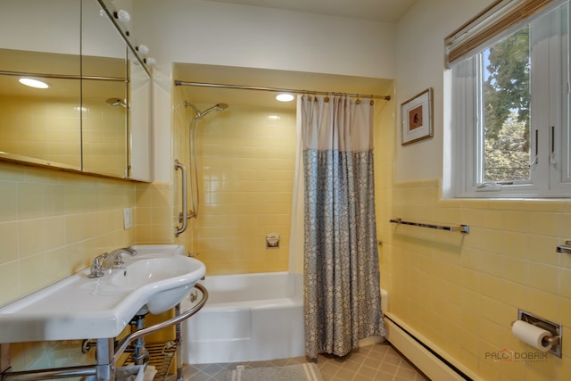 bathroom with tile patterned floors, shower / bath combination with curtain, tile walls, and sink