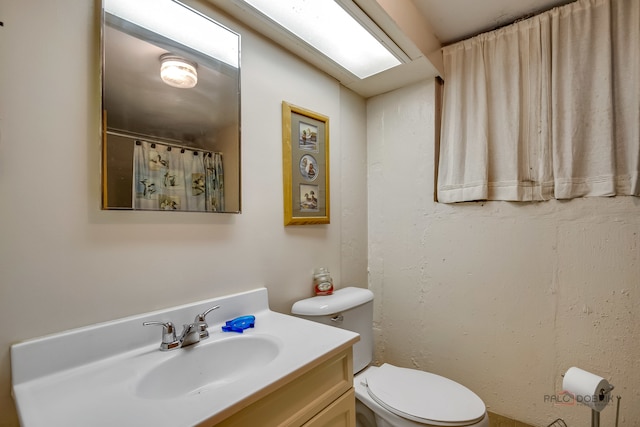 bathroom featuring toilet and vanity