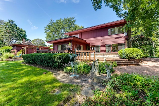 back of house featuring a wooden deck and a yard