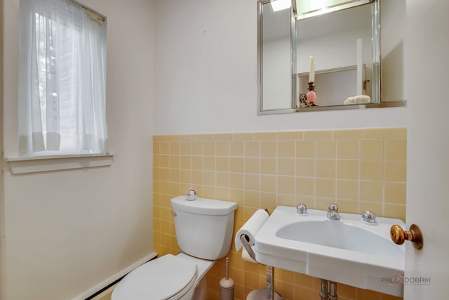 bathroom with toilet and tile walls