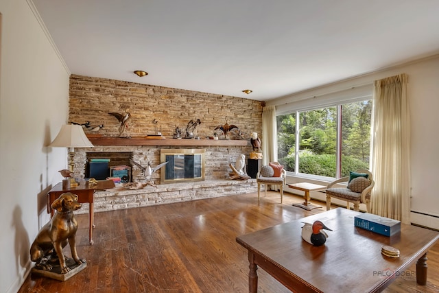 living room with a fireplace, ornamental molding, and hardwood / wood-style flooring