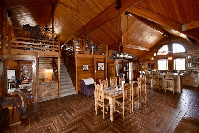 dining room featuring wood walls, wood ceiling, stairs, and beamed ceiling