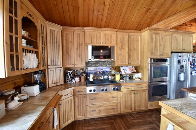 kitchen with backsplash, appliances with stainless steel finishes, tile countertops, wood ceiling, and light brown cabinetry