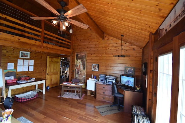home office featuring a wealth of natural light, vaulted ceiling with beams, wooden walls, and a ceiling fan
