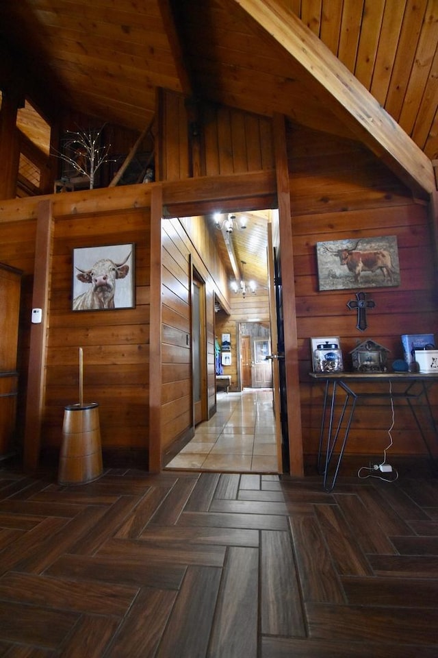 hall featuring wood walls and vaulted ceiling with beams