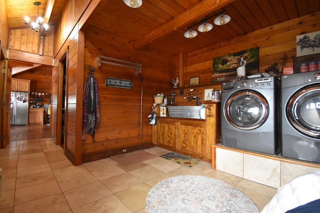 laundry area featuring a sink, wood walls, independent washer and dryer, and wood ceiling
