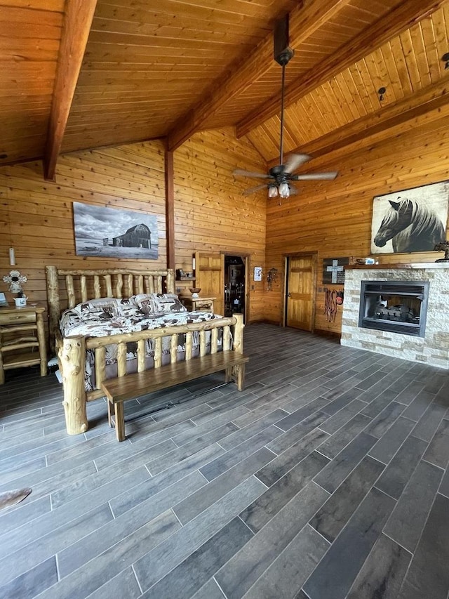 bedroom with wood ceiling, wooden walls, lofted ceiling with beams, and a stone fireplace