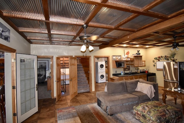 living room with stacked washer and dryer, ceiling fan, and stairs