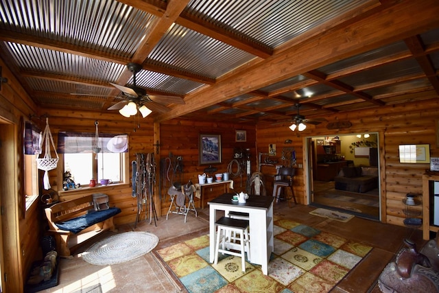 dining area featuring wooden walls, beam ceiling, and ceiling fan