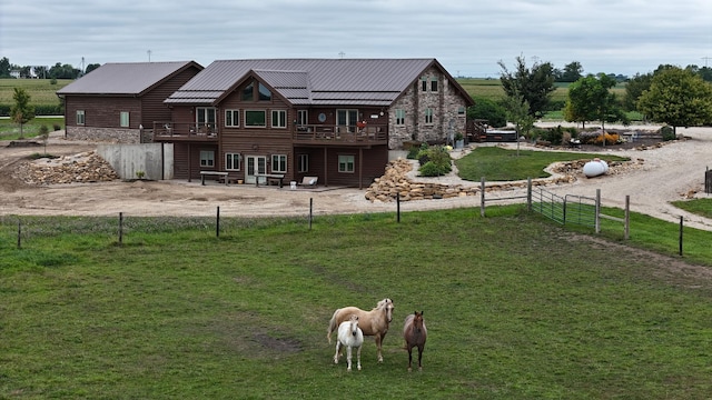 rear view of property with a yard, fence private yard, stone siding, and a wooden deck