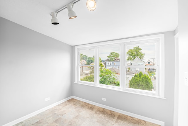 unfurnished room featuring rail lighting and light tile patterned floors