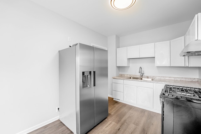 kitchen with high end fridge, sink, white cabinetry, and light wood-type flooring