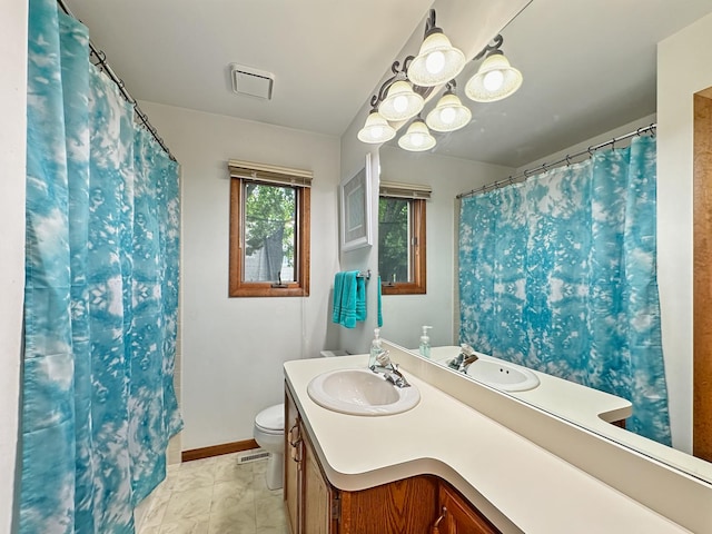 bathroom with vanity, toilet, baseboards, and visible vents