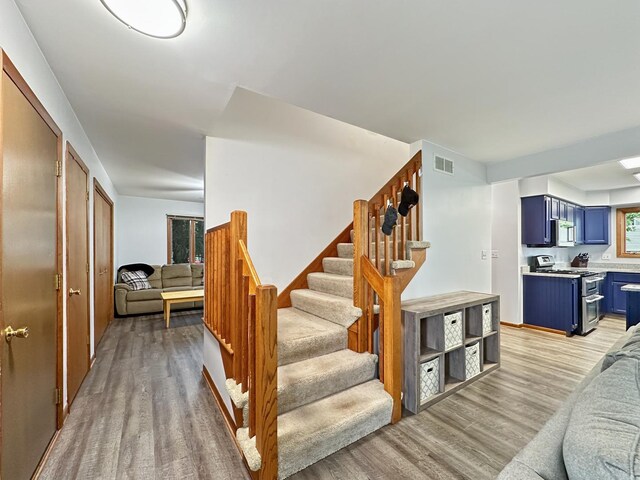 stairway featuring visible vents and wood finished floors