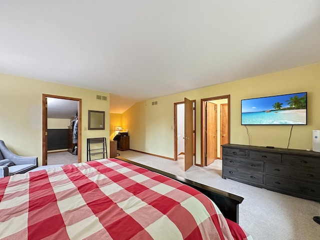 bedroom featuring a walk in closet, visible vents, a closet, and light carpet