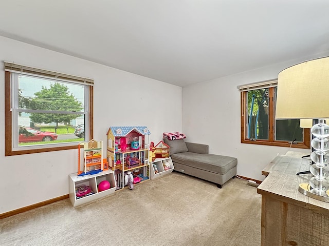 recreation room featuring baseboards, plenty of natural light, and carpet