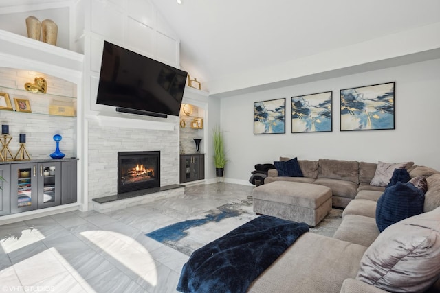 living room featuring lofted ceiling and a stone fireplace