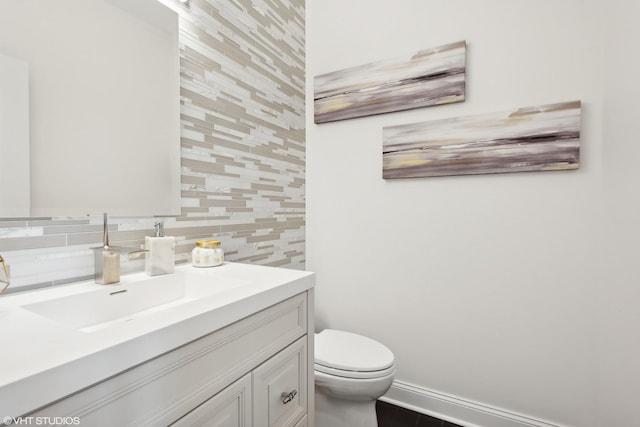 bathroom featuring vanity, backsplash, and toilet