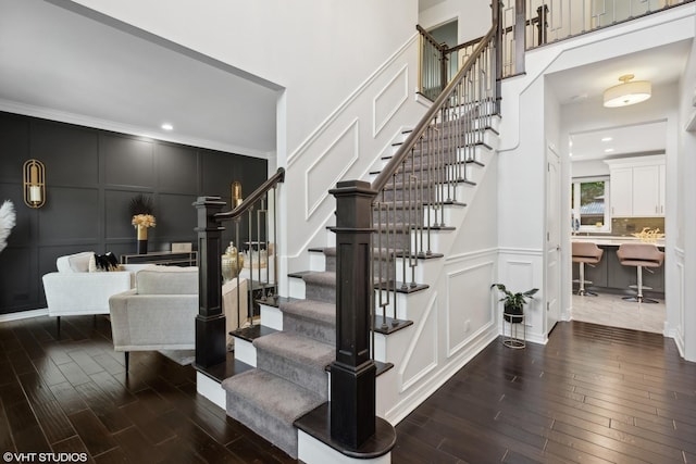 stairs featuring crown molding and hardwood / wood-style floors