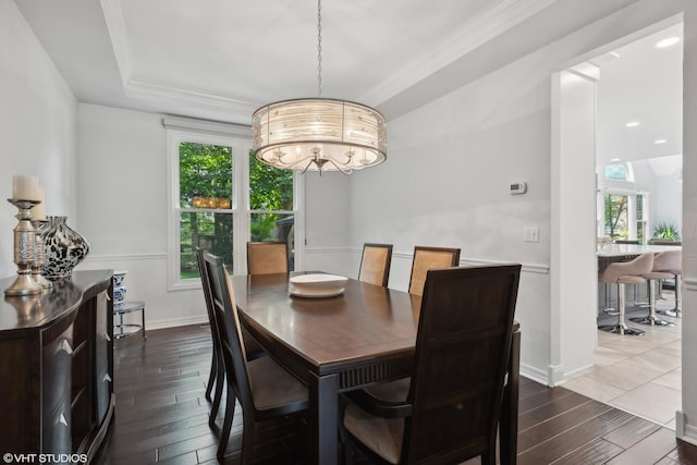 dining area with a tray ceiling, ornamental molding, and dark hardwood / wood-style floors