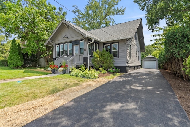 view of front of house featuring a garage, an outbuilding, and a front yard