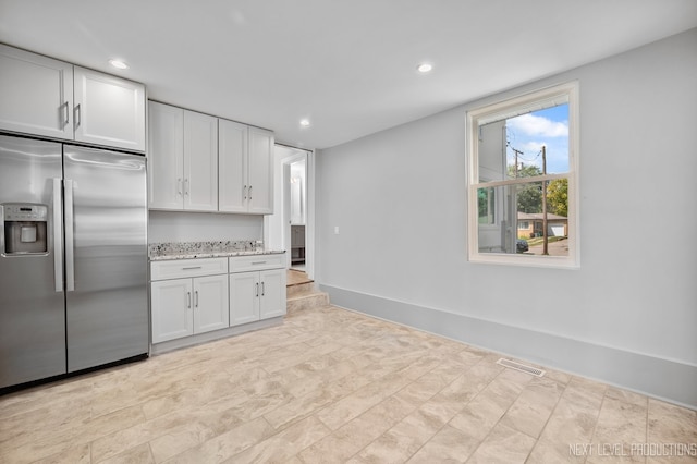 kitchen with light stone counters, recessed lighting, visible vents, white cabinets, and stainless steel built in refrigerator