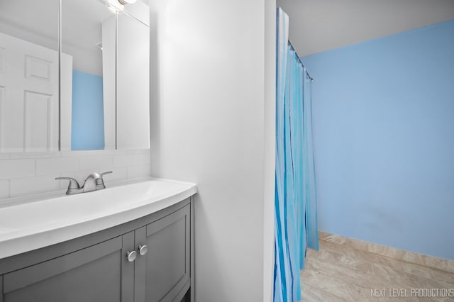 full bath featuring backsplash and vanity