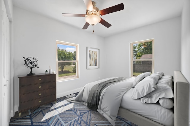 bedroom with ceiling fan and multiple windows