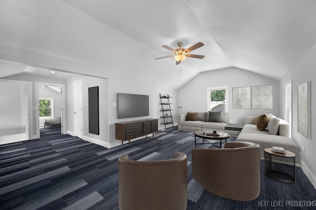 living room featuring a wealth of natural light, baseboards, vaulted ceiling, and dark colored carpet